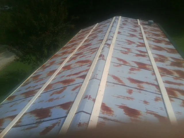 Rusted metal roof panels with new wood purlins before replacement — Storm Damage Roof Repair in Alexis by Roofing Brothers